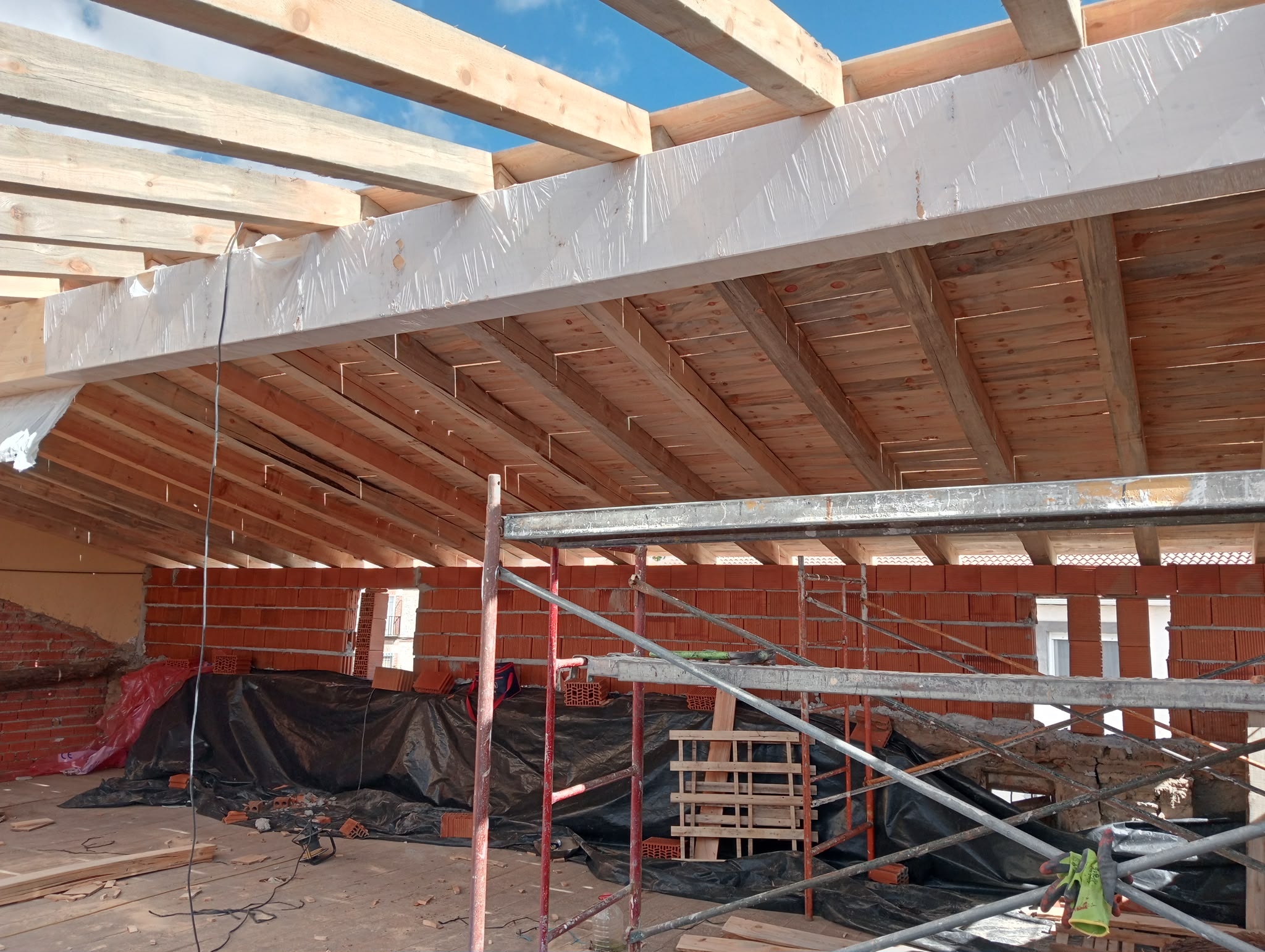 Estructura de vigas de madera de una cubierta con andamio en obra